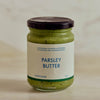 A glass jar of Portside Parsley Butter with a dark lid and a cream label, set against a soft, light beige marble background.