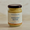 A glass jar of Portside Vadouvan Butter with a dark lid and a cream-colored label, set against a neutral, light beige background.